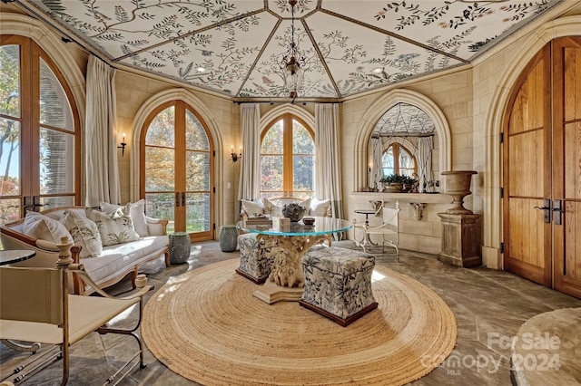 sitting room with crown molding, tile walls, dark tile floors, and french doors