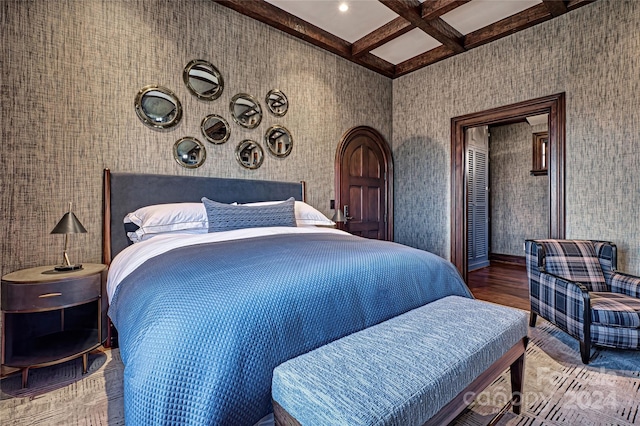 bedroom featuring coffered ceiling, dark wood-type flooring, and beamed ceiling