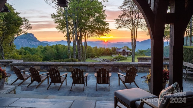 patio terrace at dusk featuring a mountain view