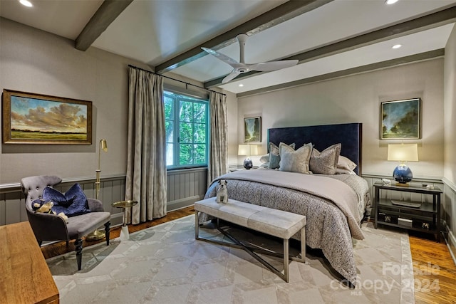 bedroom with beam ceiling, ceiling fan, and light hardwood / wood-style flooring