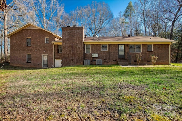 rear view of house featuring a lawn and central air condition unit