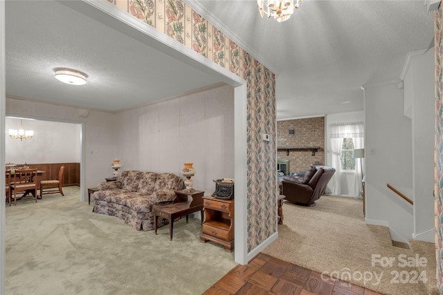 living room with a fireplace, light carpet, a textured ceiling, a chandelier, and ornamental molding