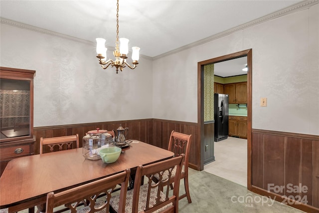 dining area featuring an inviting chandelier, ornamental molding, and light colored carpet