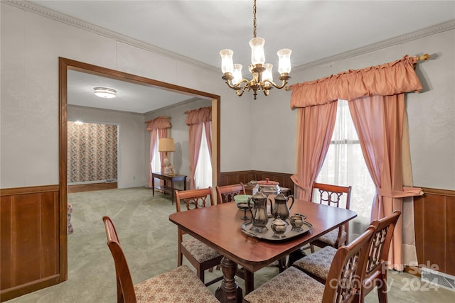 carpeted dining area featuring crown molding and a chandelier