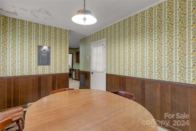 dining area featuring ornamental molding and wooden walls