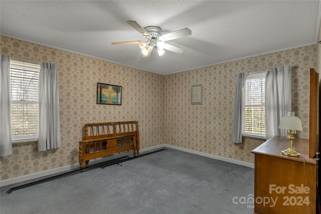 carpeted empty room featuring crown molding, a textured ceiling, and ceiling fan