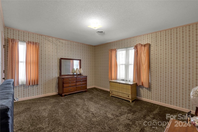 unfurnished bedroom featuring a textured ceiling and dark carpet