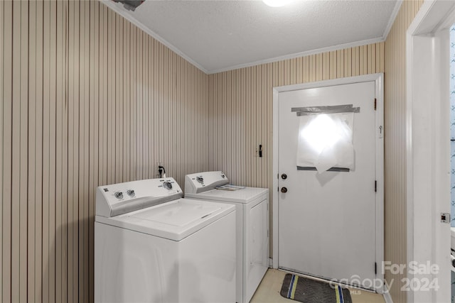 washroom with a textured ceiling, ornamental molding, and separate washer and dryer