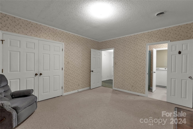 sitting room with light carpet, washer / clothes dryer, a textured ceiling, and ornamental molding