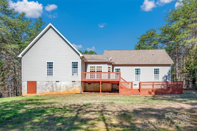 back of property with a wooden deck and a yard