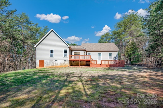 rear view of house with a wooden deck and a yard