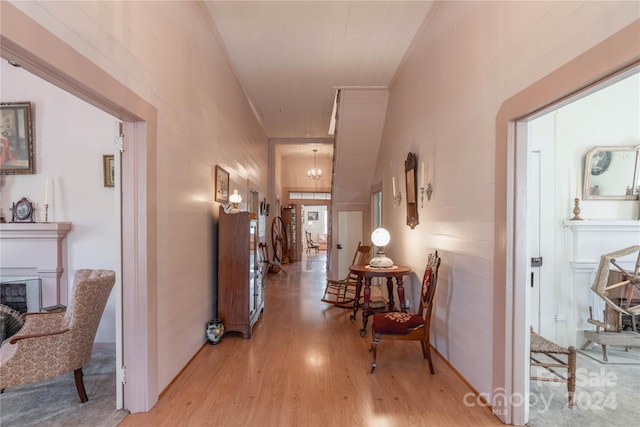 hallway featuring light hardwood / wood-style flooring and a chandelier