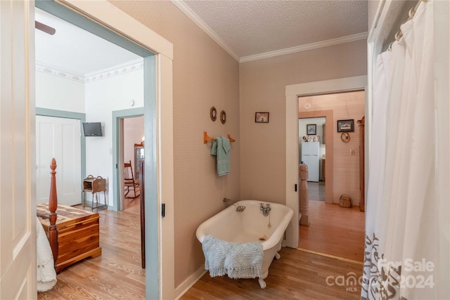 bathroom with hardwood / wood-style floors, a textured ceiling, and ornamental molding