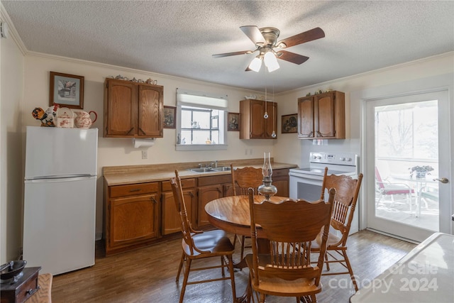 kitchen featuring white appliances, hardwood / wood-style floors, a textured ceiling, and ceiling fan