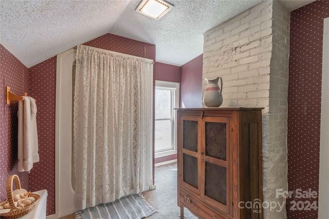 interior space with light carpet, a textured ceiling, and lofted ceiling