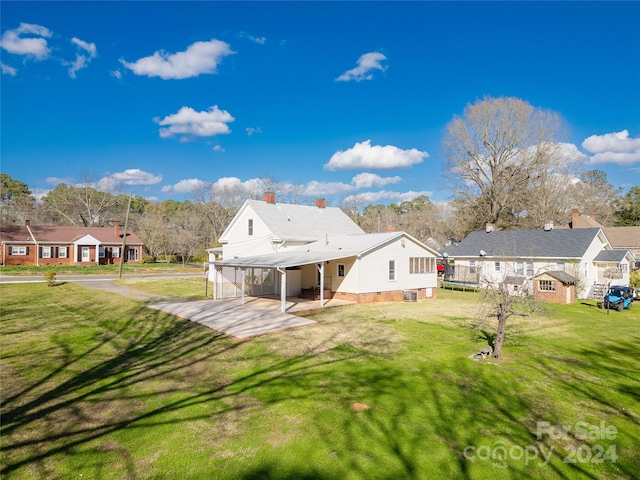 back of house with a yard and a carport