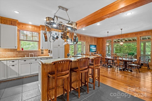 kitchen featuring a kitchen island, light stone counters, white cabinetry, and dark hardwood / wood-style floors