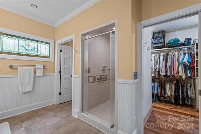 bathroom with crown molding, tiled shower, and wood-type flooring