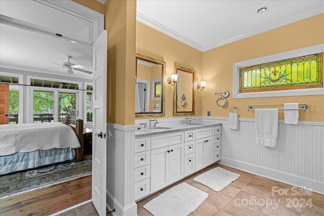 bathroom featuring double sink, ceiling fan, crown molding, wood-type flooring, and large vanity