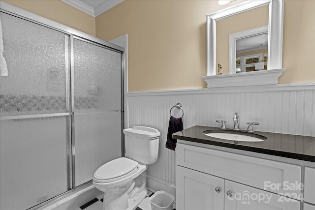 bathroom featuring a shower with door, oversized vanity, toilet, and crown molding