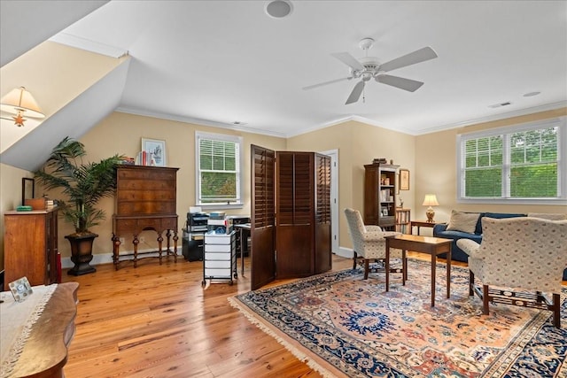 living area featuring ornamental molding, light hardwood / wood-style flooring, and a wealth of natural light