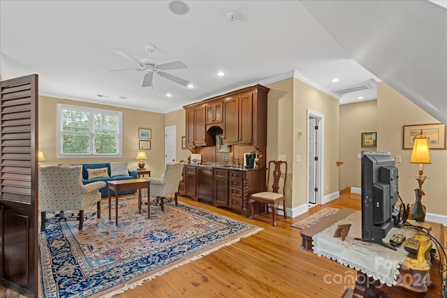 interior space featuring ceiling fan, crown molding, and light wood-type flooring