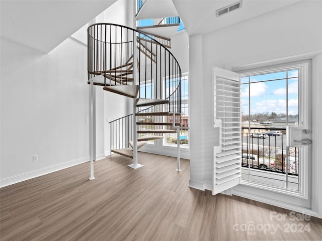 staircase featuring wood-type flooring and a healthy amount of sunlight