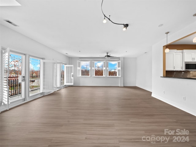 unfurnished living room with ceiling fan and hardwood / wood-style flooring