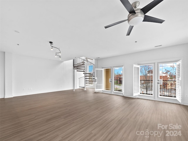 spare room featuring dark hardwood / wood-style flooring, ceiling fan, and track lighting