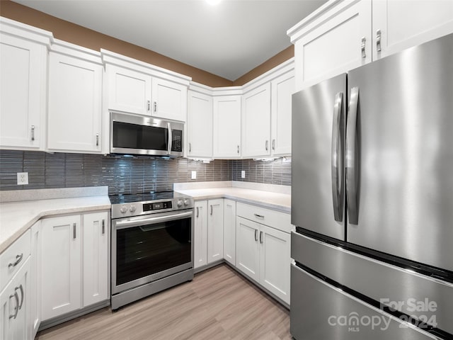 kitchen featuring light hardwood / wood-style floors, tasteful backsplash, stainless steel appliances, and white cabinetry