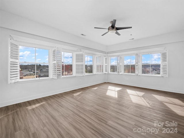 unfurnished room with ceiling fan and dark hardwood / wood-style flooring