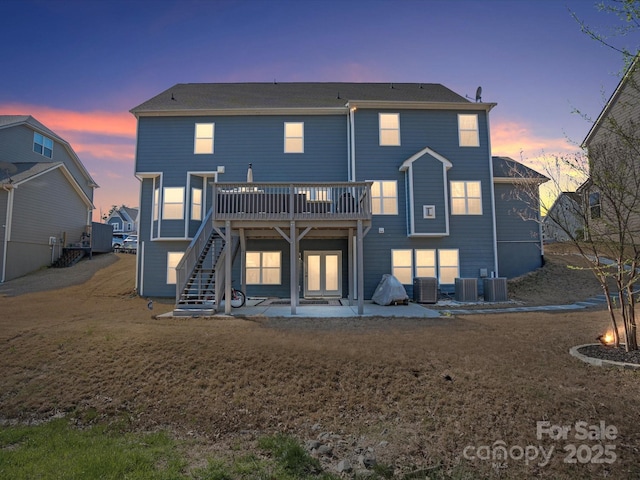 back house at dusk featuring a yard, a patio area, and a wooden deck