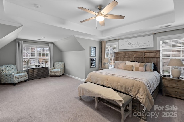 bedroom with multiple windows, carpet floors, a raised ceiling, and ceiling fan