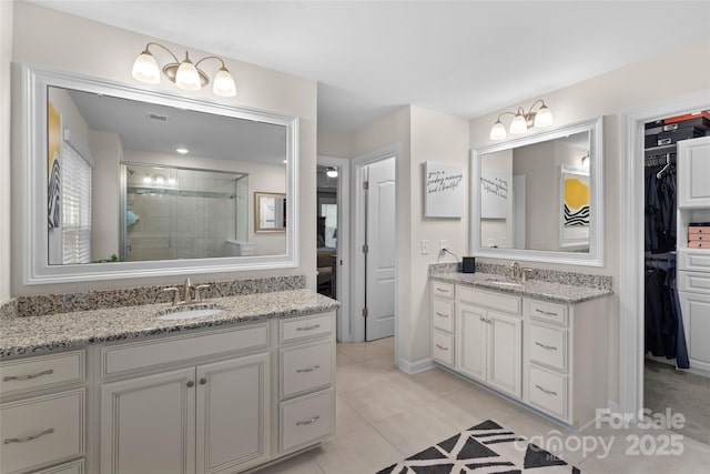 bathroom with tile patterned floors, vanity, and a shower with door