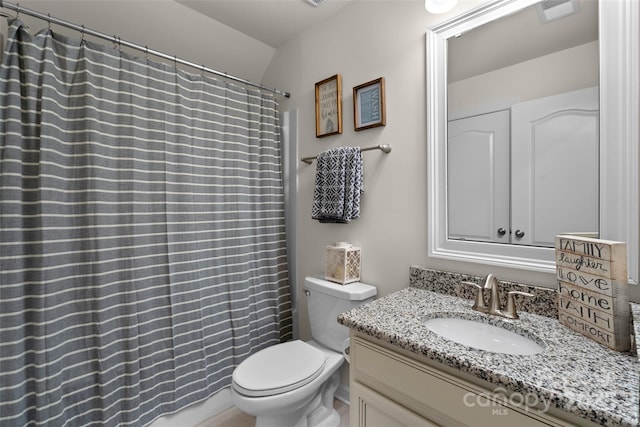 bathroom featuring vanity, lofted ceiling, and toilet