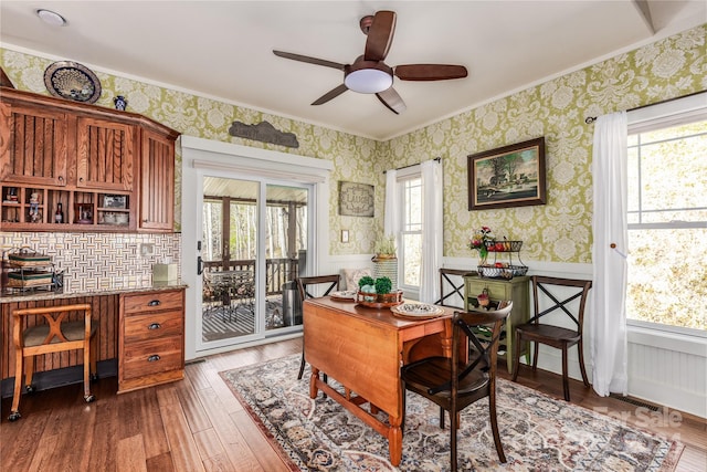 dining area featuring ceiling fan, dark wood-type flooring, plenty of natural light, and ornamental molding