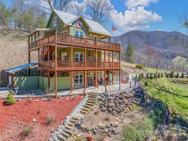 back of house with a patio area and a deck with mountain view