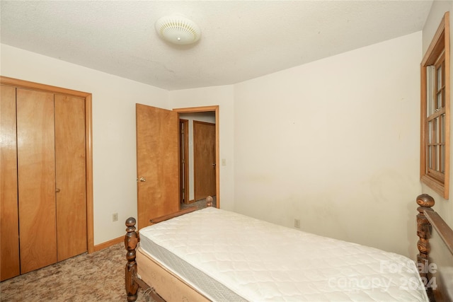 carpeted bedroom featuring a closet and a textured ceiling