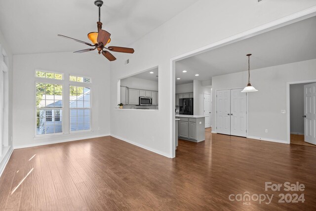 unfurnished living room with vaulted ceiling, dark hardwood / wood-style flooring, and ceiling fan