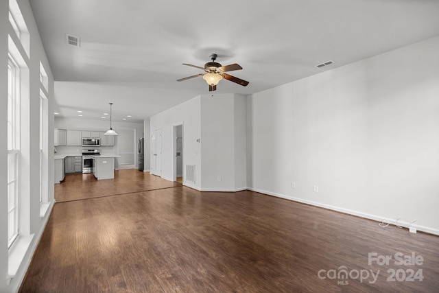 unfurnished living room featuring ceiling fan and dark hardwood / wood-style floors