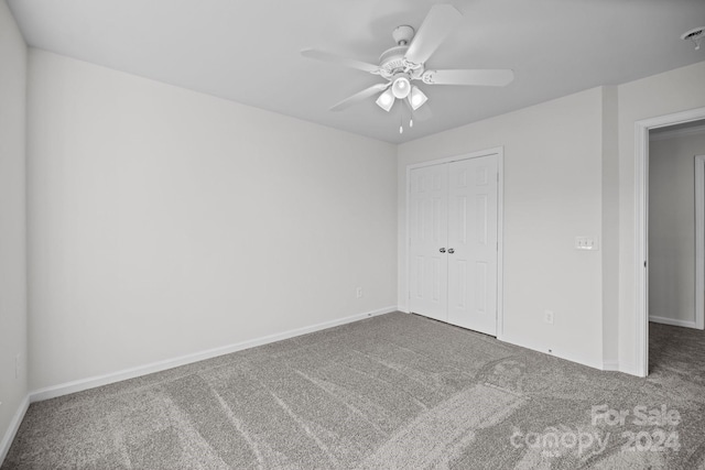 unfurnished bedroom featuring ceiling fan, a closet, and carpet