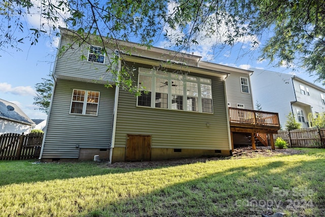 rear view of property with a wooden deck and a lawn