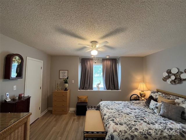 bedroom featuring a textured ceiling, ceiling fan, and light wood-type flooring