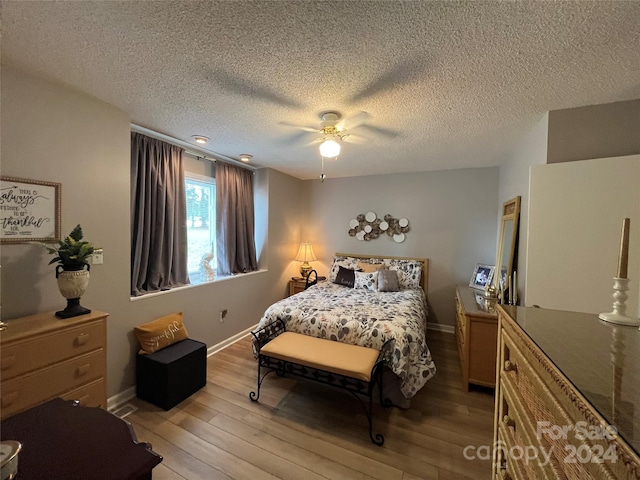 bedroom featuring a textured ceiling, ceiling fan, and light hardwood / wood-style flooring