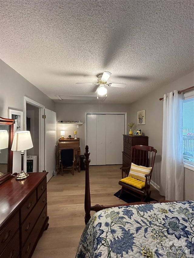 bedroom featuring a textured ceiling, a closet, ceiling fan, and light wood-type flooring