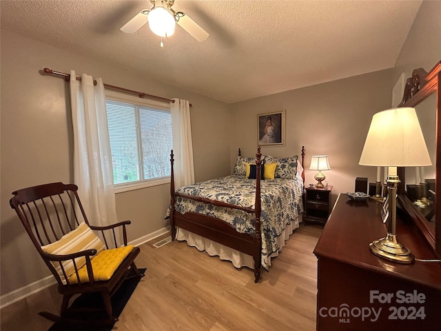 bedroom featuring ceiling fan, a textured ceiling, and light hardwood / wood-style floors