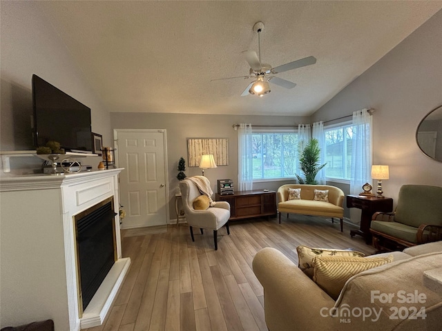 living room with light hardwood / wood-style flooring, ceiling fan, and lofted ceiling