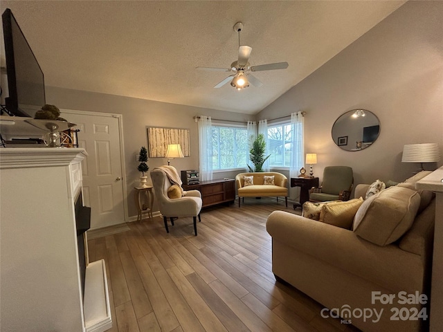 living room featuring ceiling fan, vaulted ceiling, and hardwood / wood-style flooring