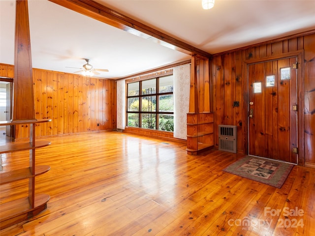 entrance foyer with wood walls, ceiling fan, and light hardwood / wood-style flooring