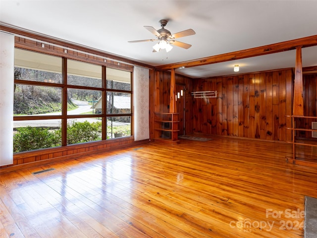 spare room with ceiling fan, light wood-type flooring, and a healthy amount of sunlight